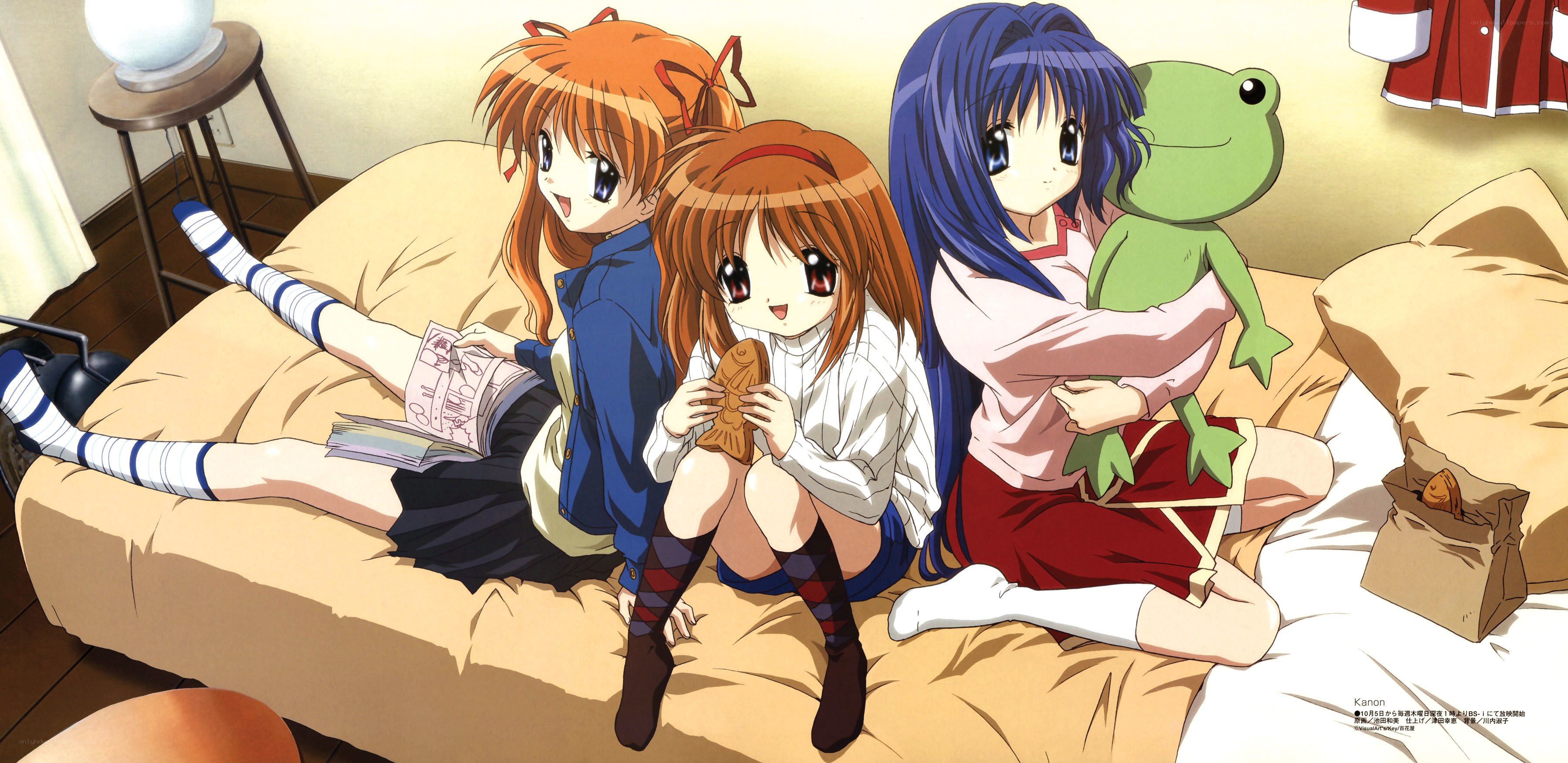 Three girls on a bed with snacks