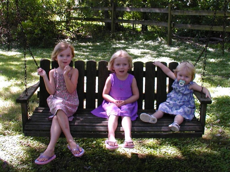 Three girls on a swing bench