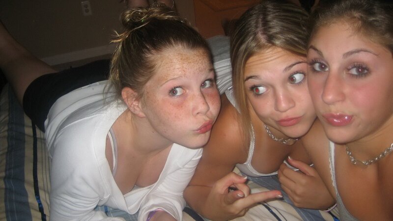 three girls posing on a bed