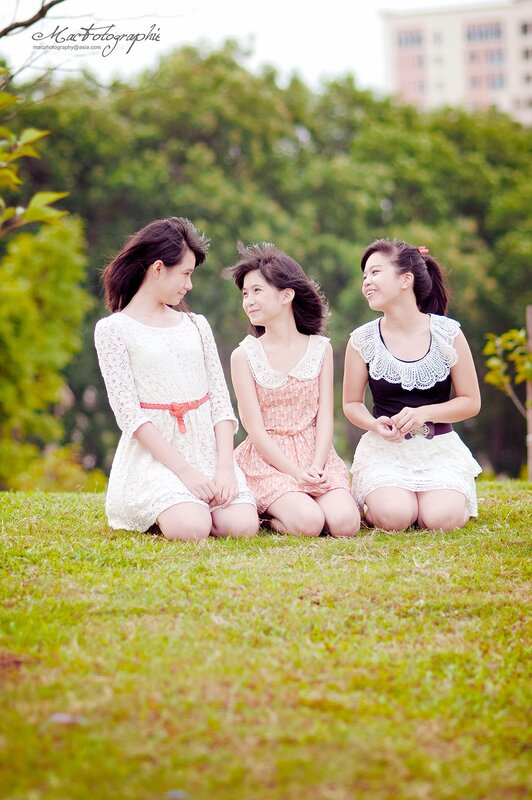 three girls sitting on grass