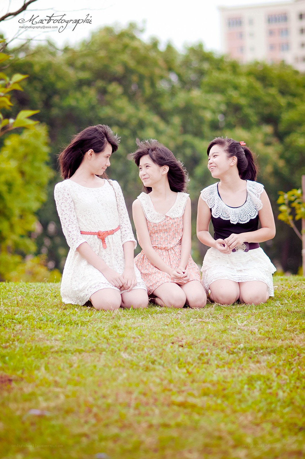 three girls sitting on grass