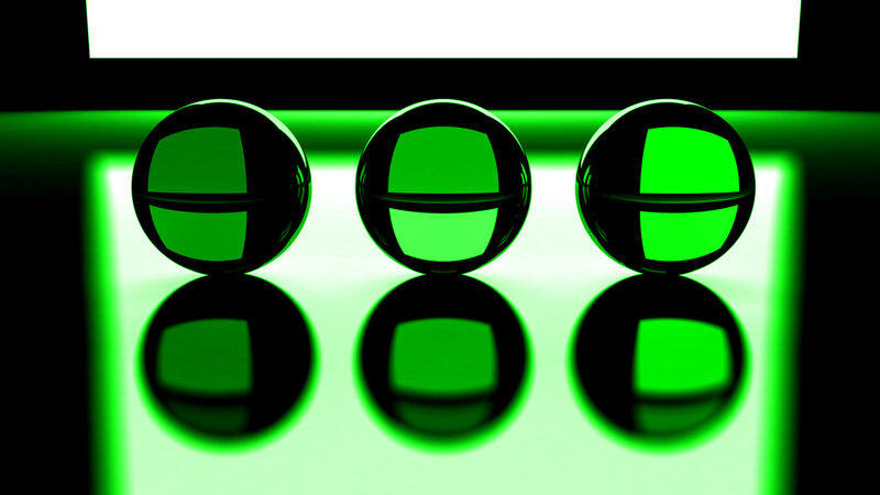 Three green spheres on reflective surface