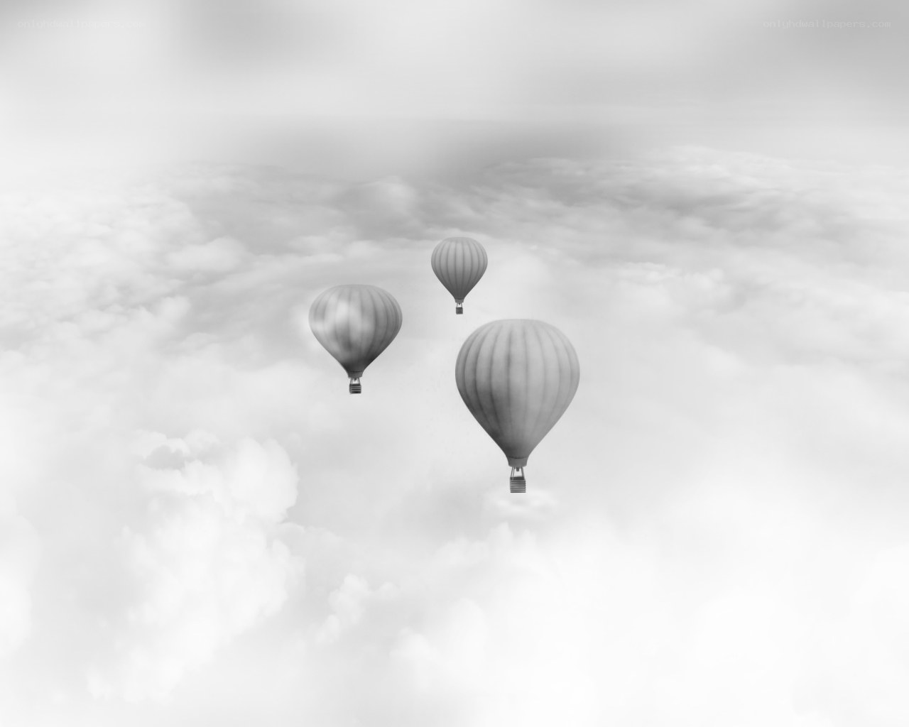 Three hot air balloons in clouds