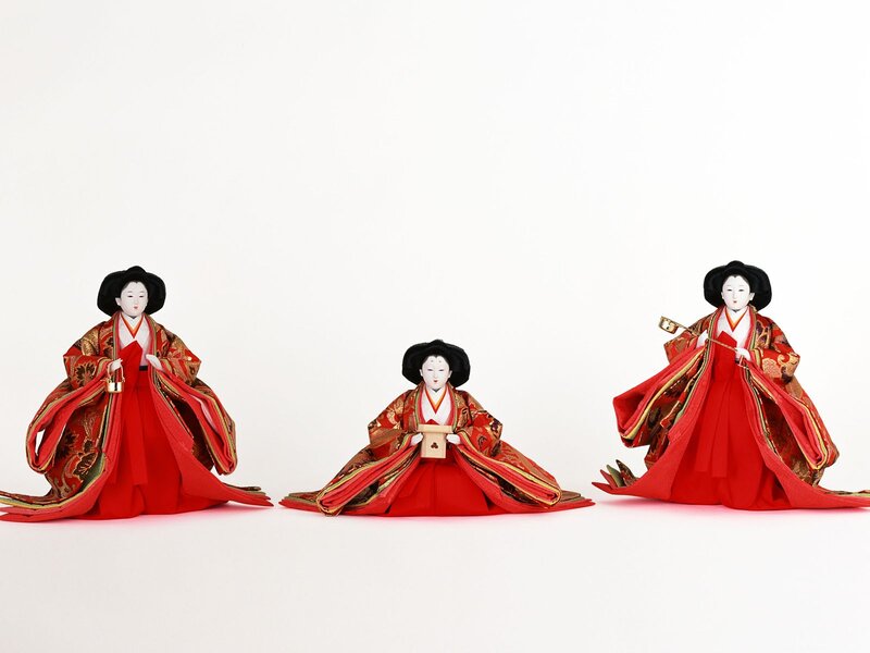 Three Japanese dolls in red kimonos