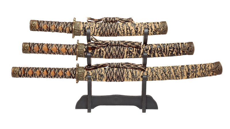 Three Japanese swords on display stand