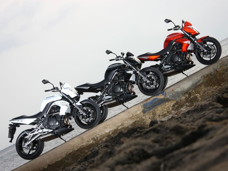 Three Kawasaki motorcycles on a slope