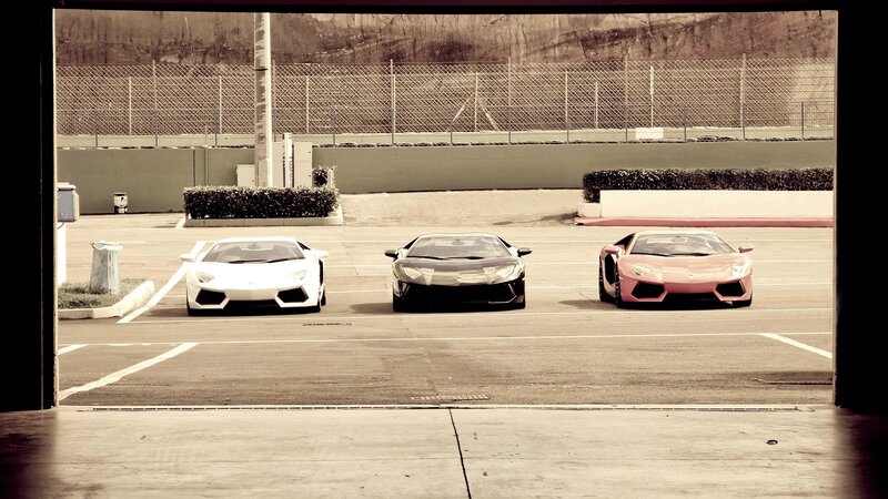 Three Lamborghini cars in a garage