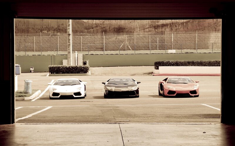Three Lamborghinis at a racetrack