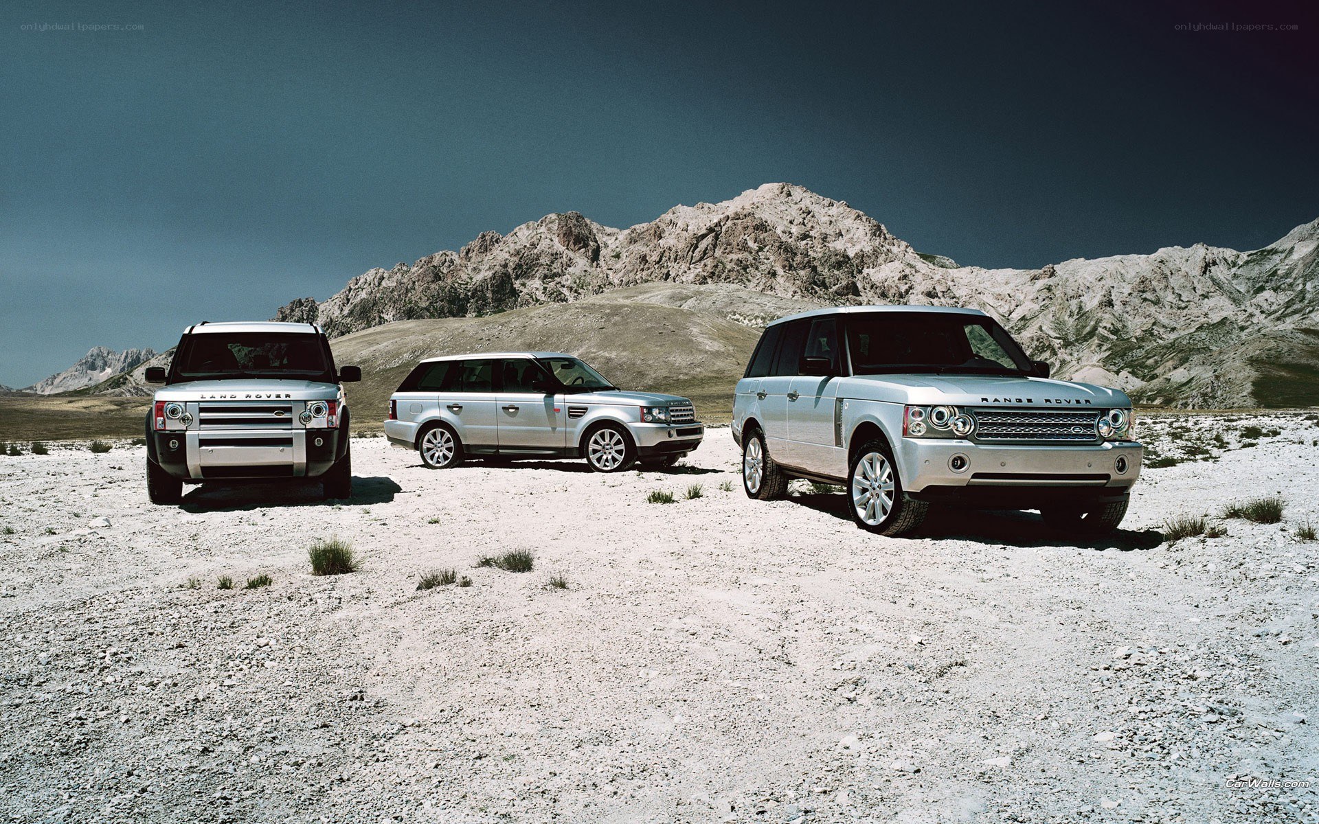 Three Land Rover SUVs in desert