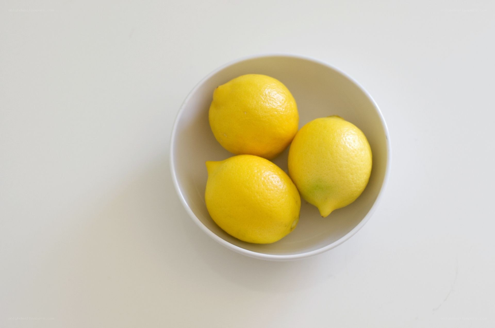 three lemons in a bowl