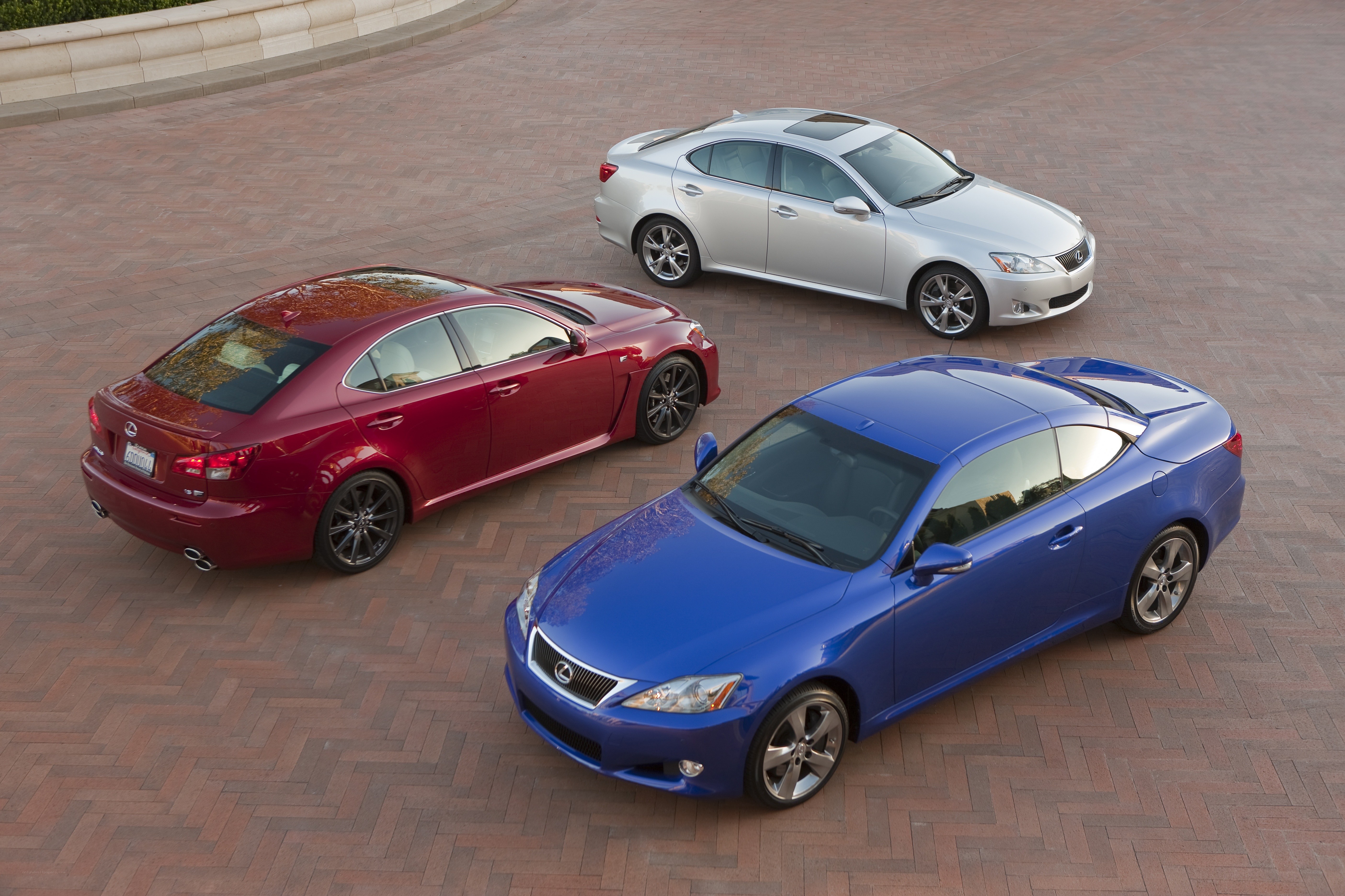 Three Lexus cars on a brick surface