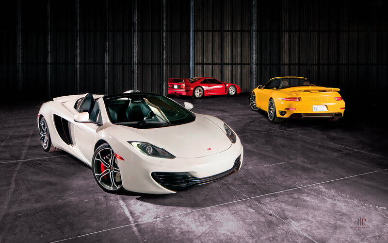 Three luxury sports cars in a garage