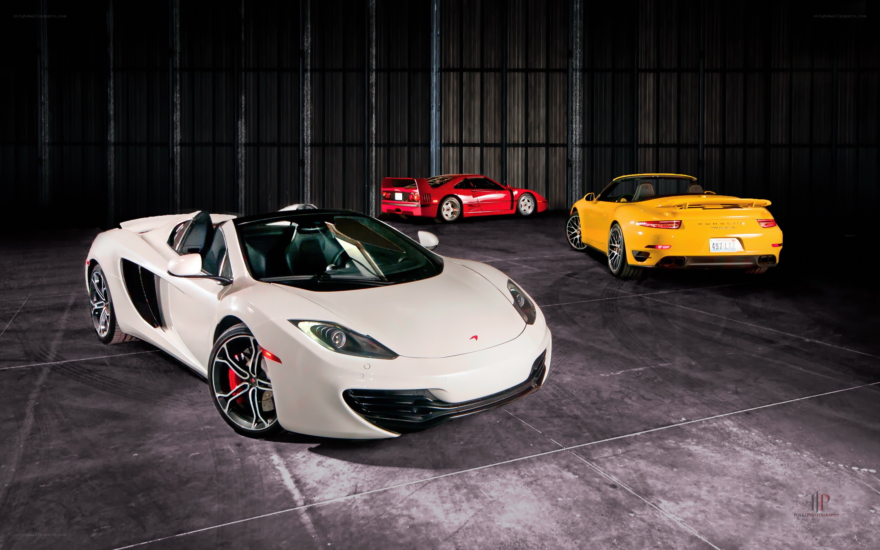 Three luxury sports cars in a garage