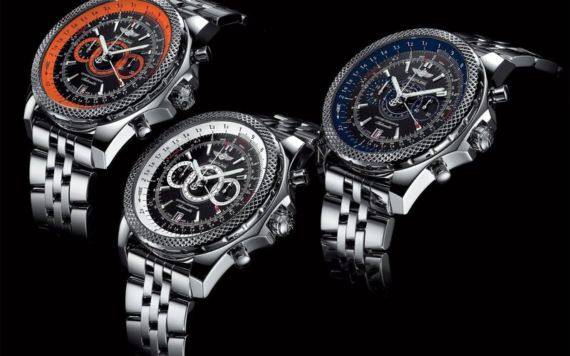 three luxury watches on black