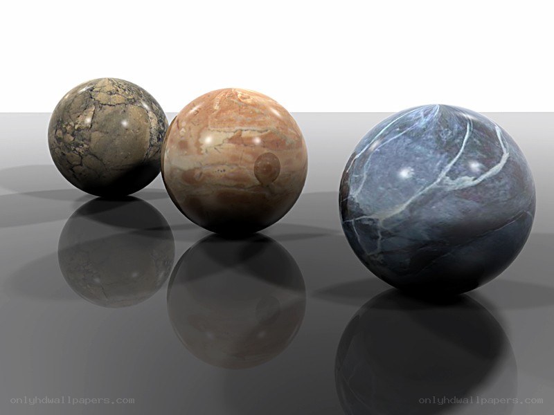 three marble spheres on reflective surface