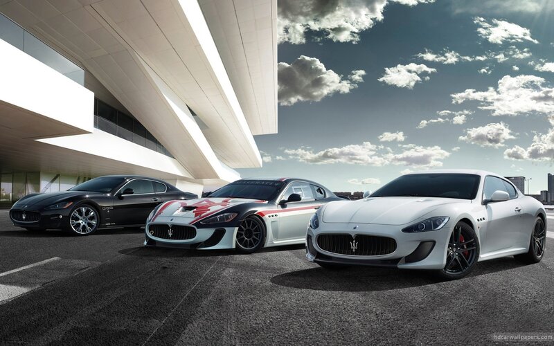 Three Maserati cars at a modern building