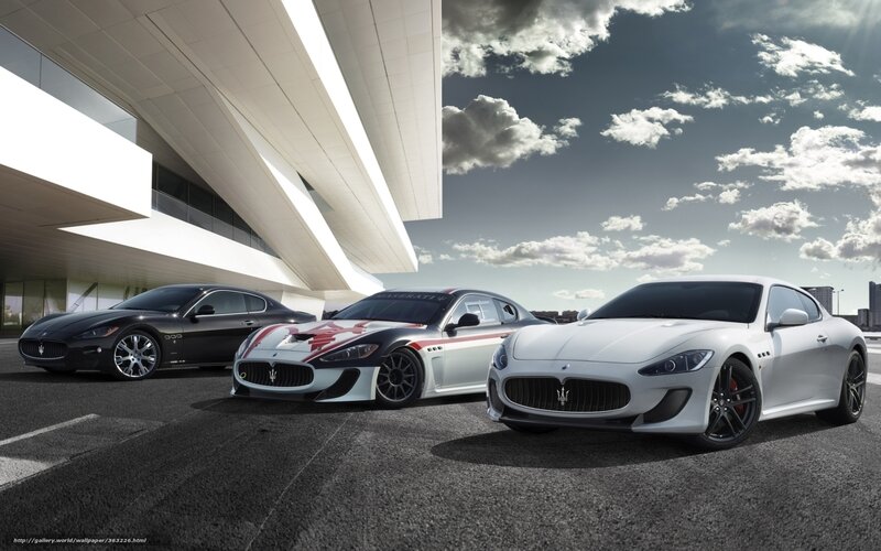 Three Maserati cars in front of building