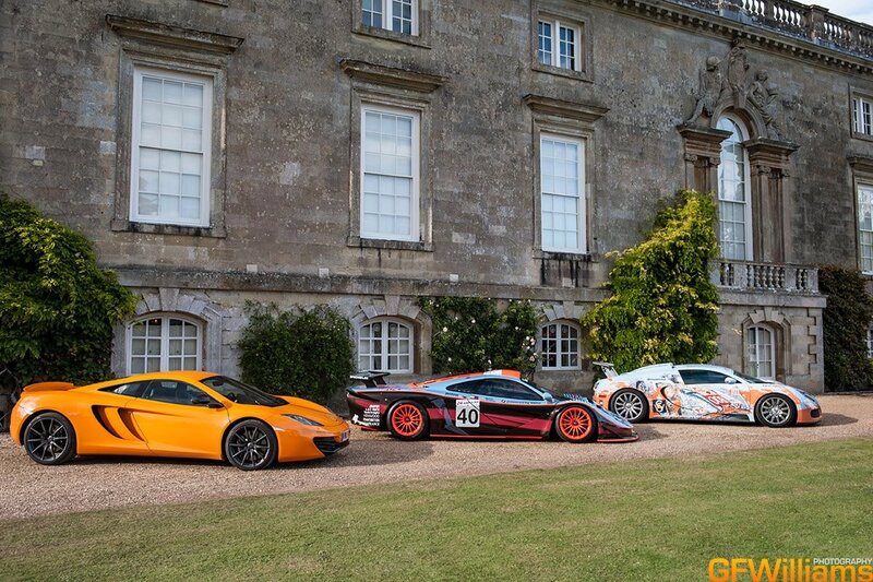 Three McLaren cars at a stately home