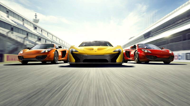 Three McLaren sports cars on a racetrack