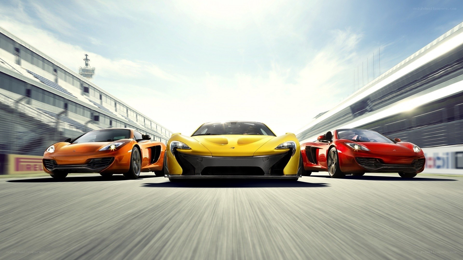 Three McLaren sports cars on a racetrack