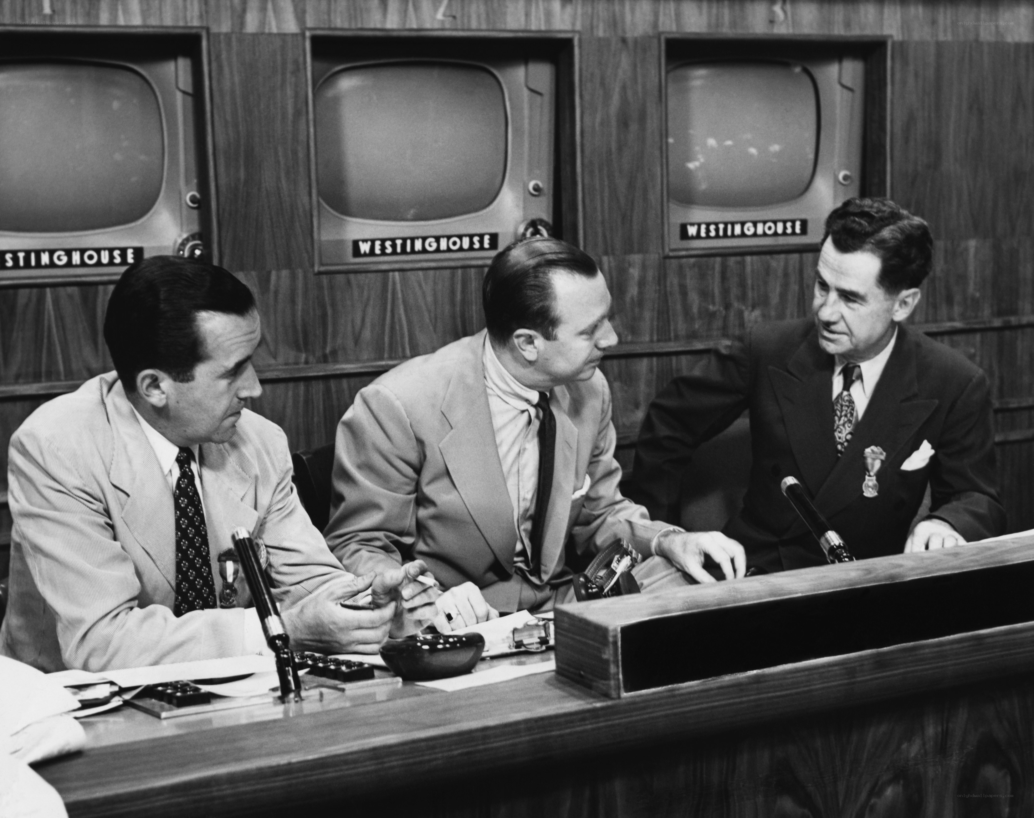 Three men at a news desk
