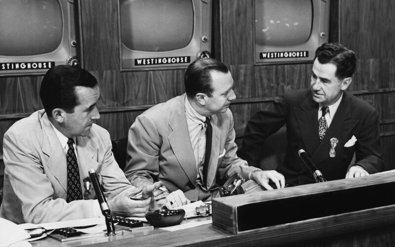Three men at a news desk