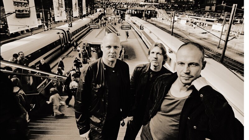 Three men at a train station