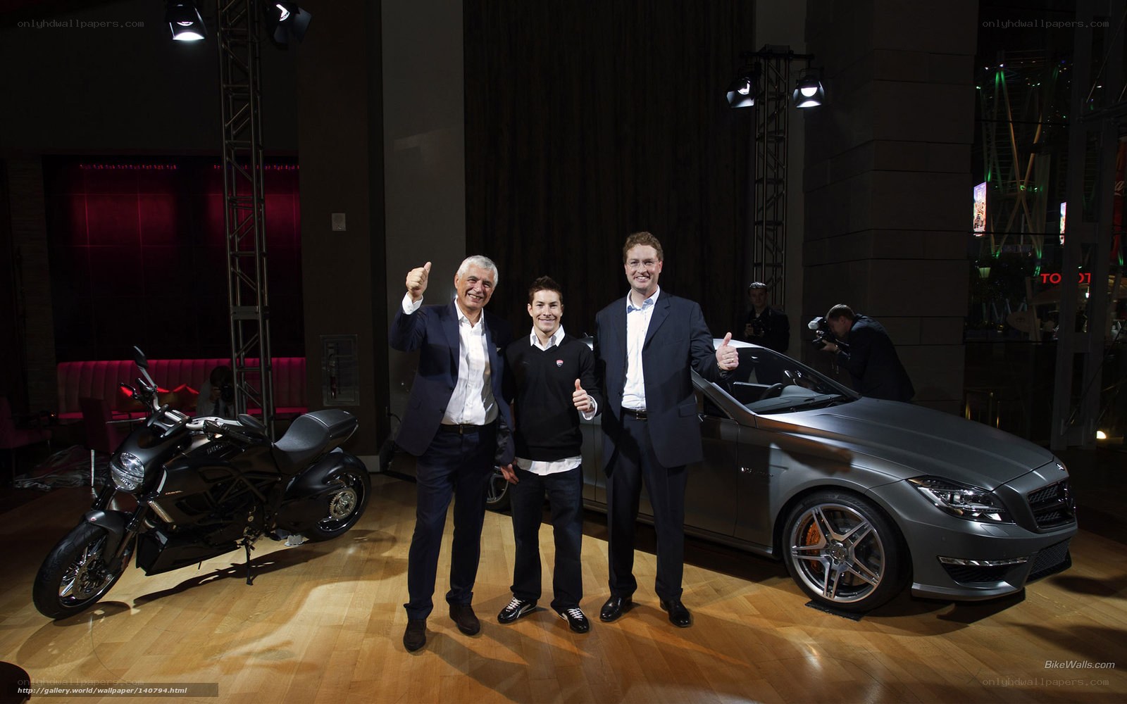 Three men at car and motorcycle event