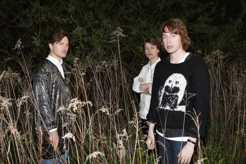 Three men in a field at night