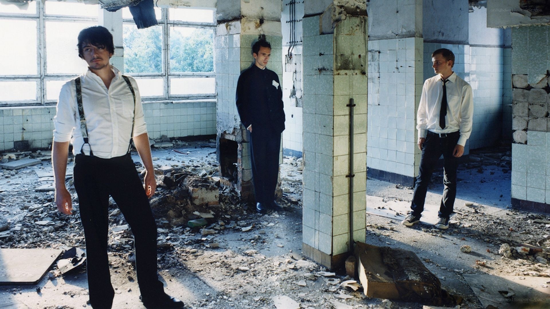 Three men in a ruined building