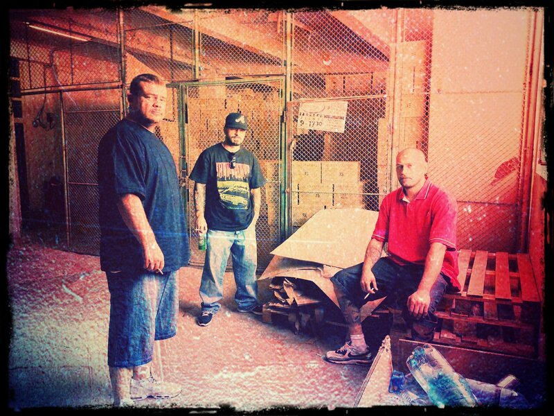 Three men in a warehouse