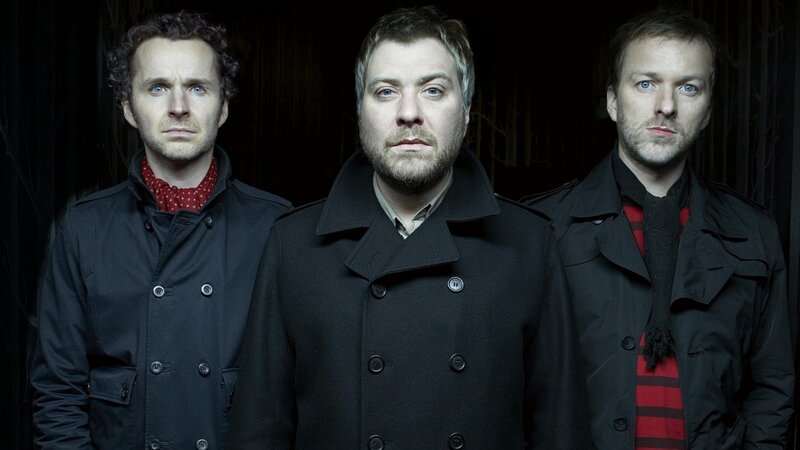 three men in black coats