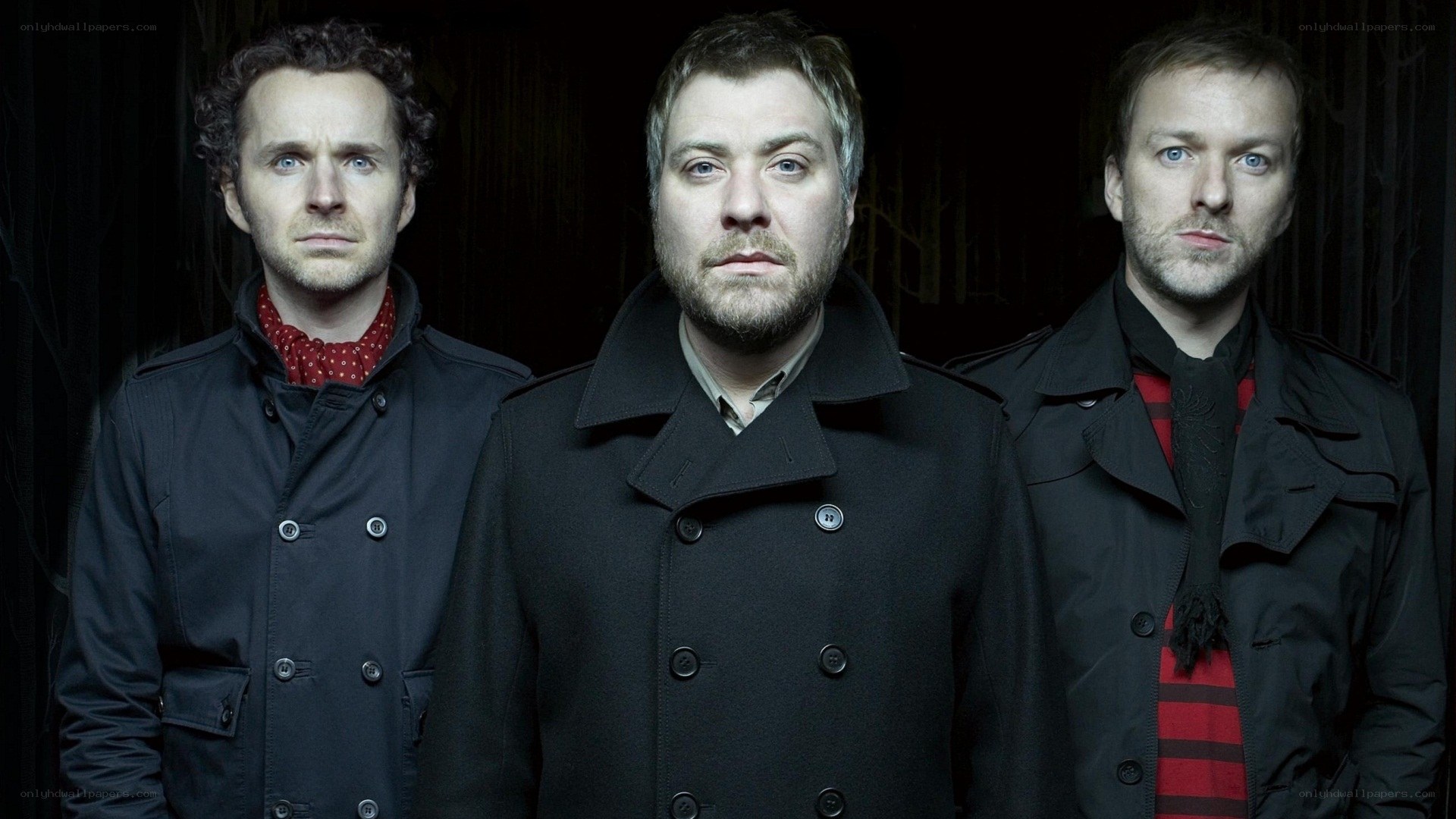 three men in black coats