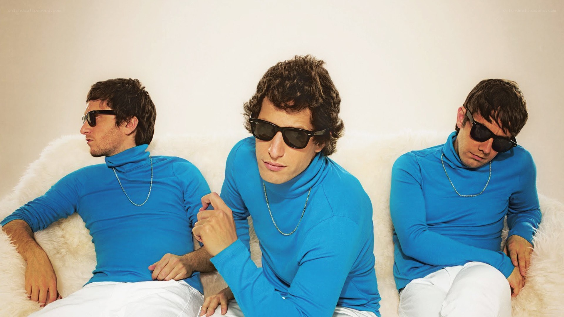 Three men in blue turtlenecks