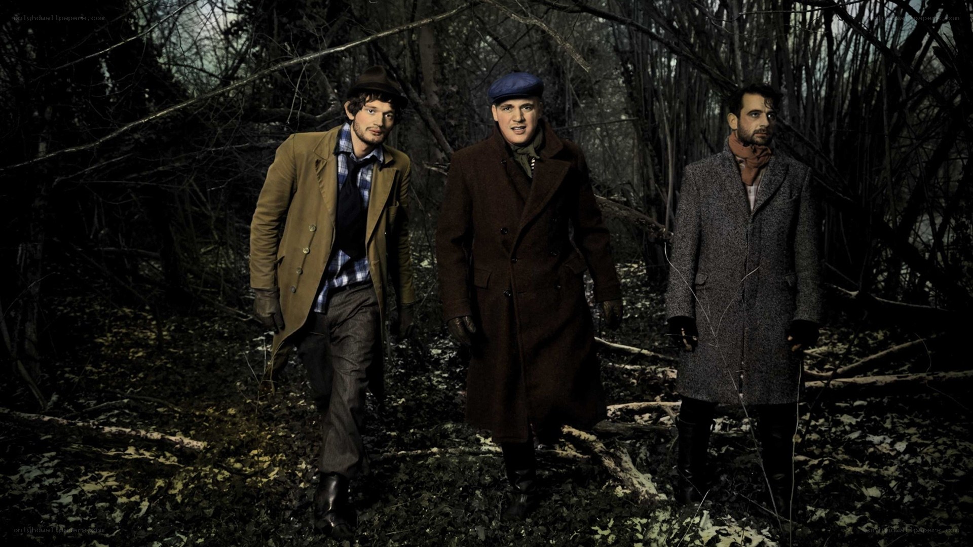 three men in coats in forest
