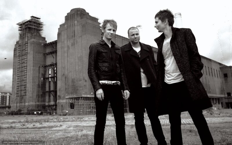 three men in front of industrial building