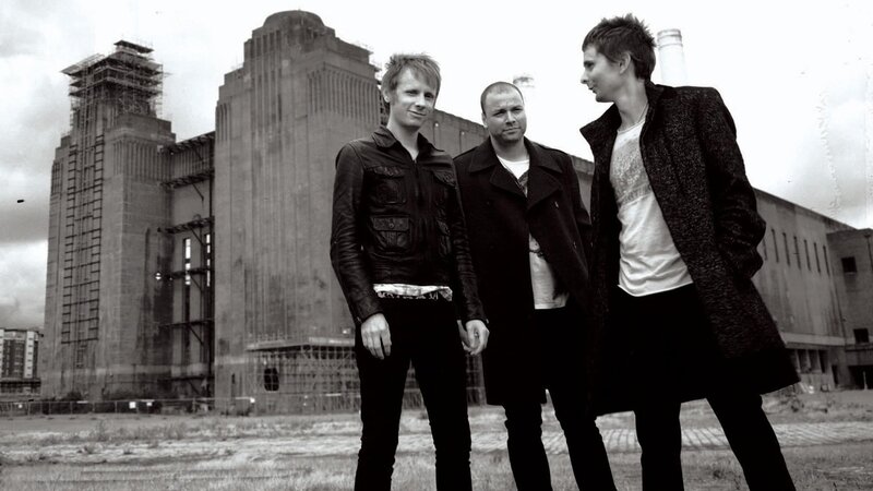 three men in front of industrial building