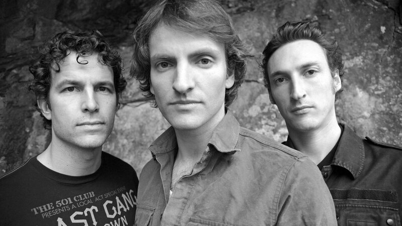 Three Men in Front of Rock