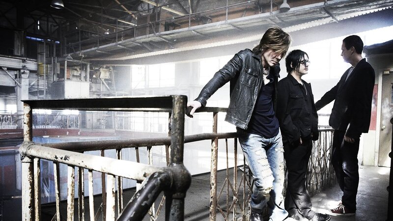 Three Men in Industrial Setting — Black