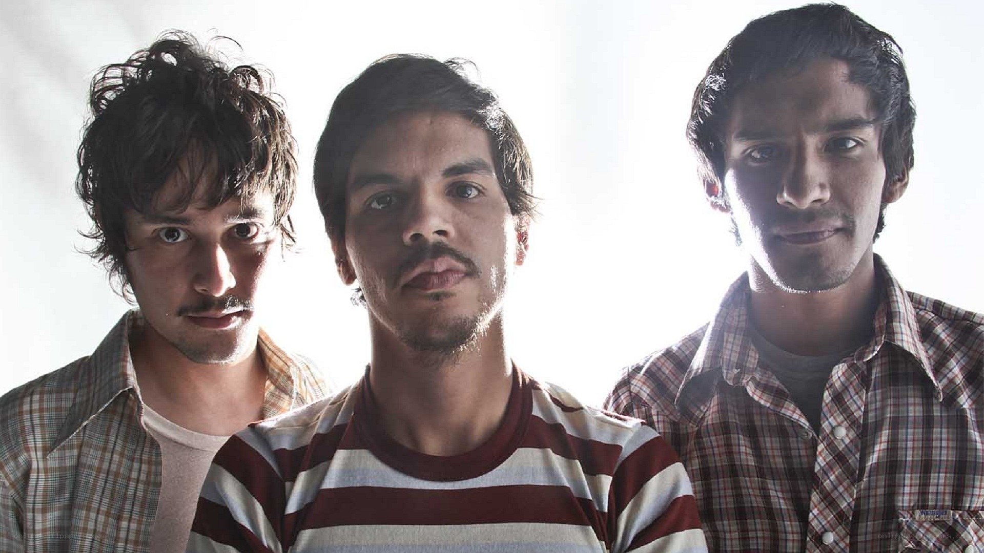 three men in striped and plaid shirts