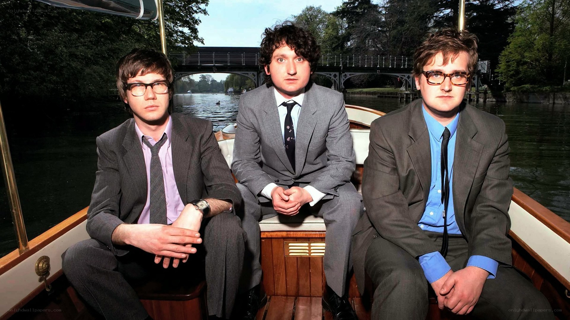 Three men in suits on a boat