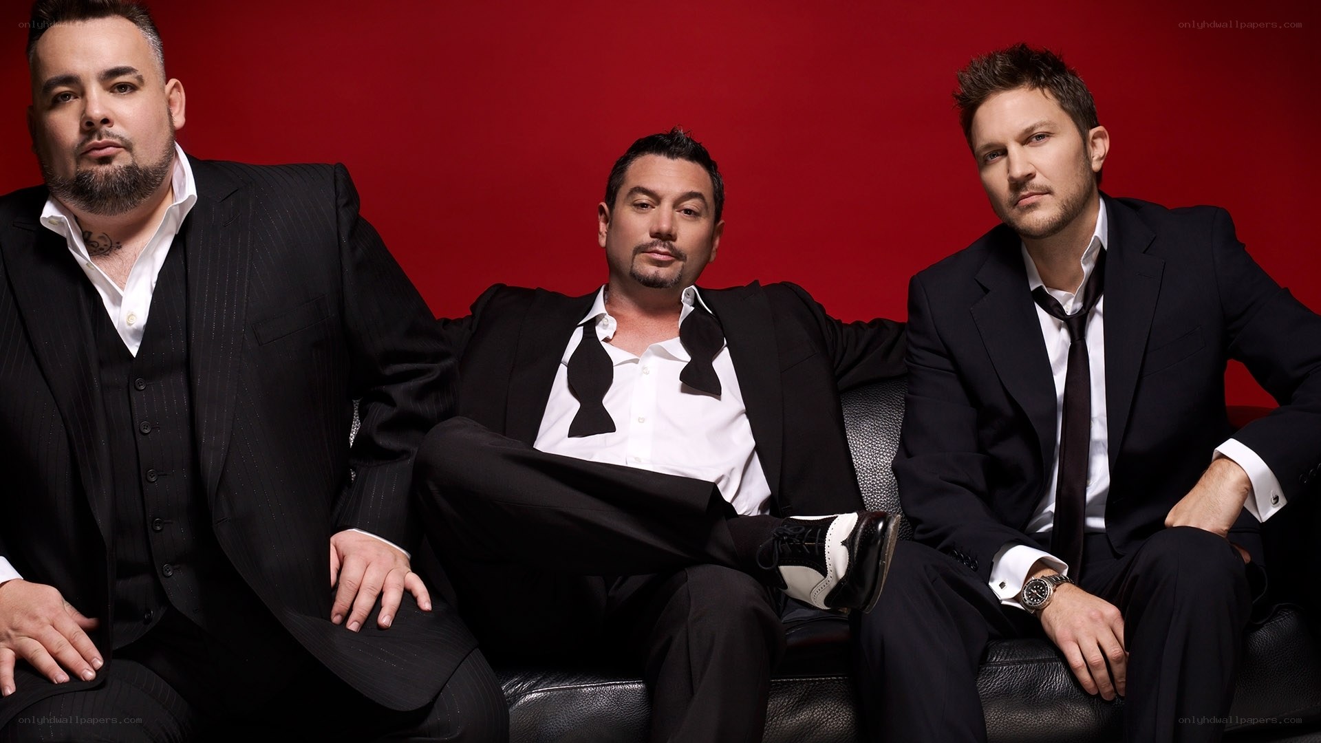 Three men in suits on a couch