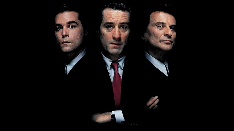 three men in suits on black background