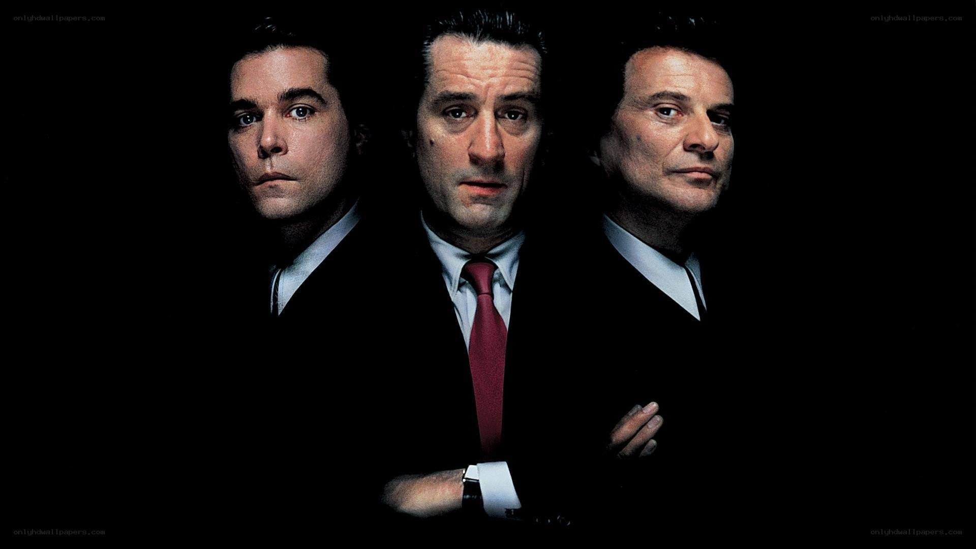 three men in suits on black background