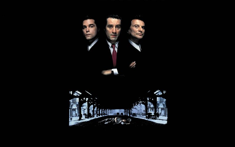 three men in suits on black background