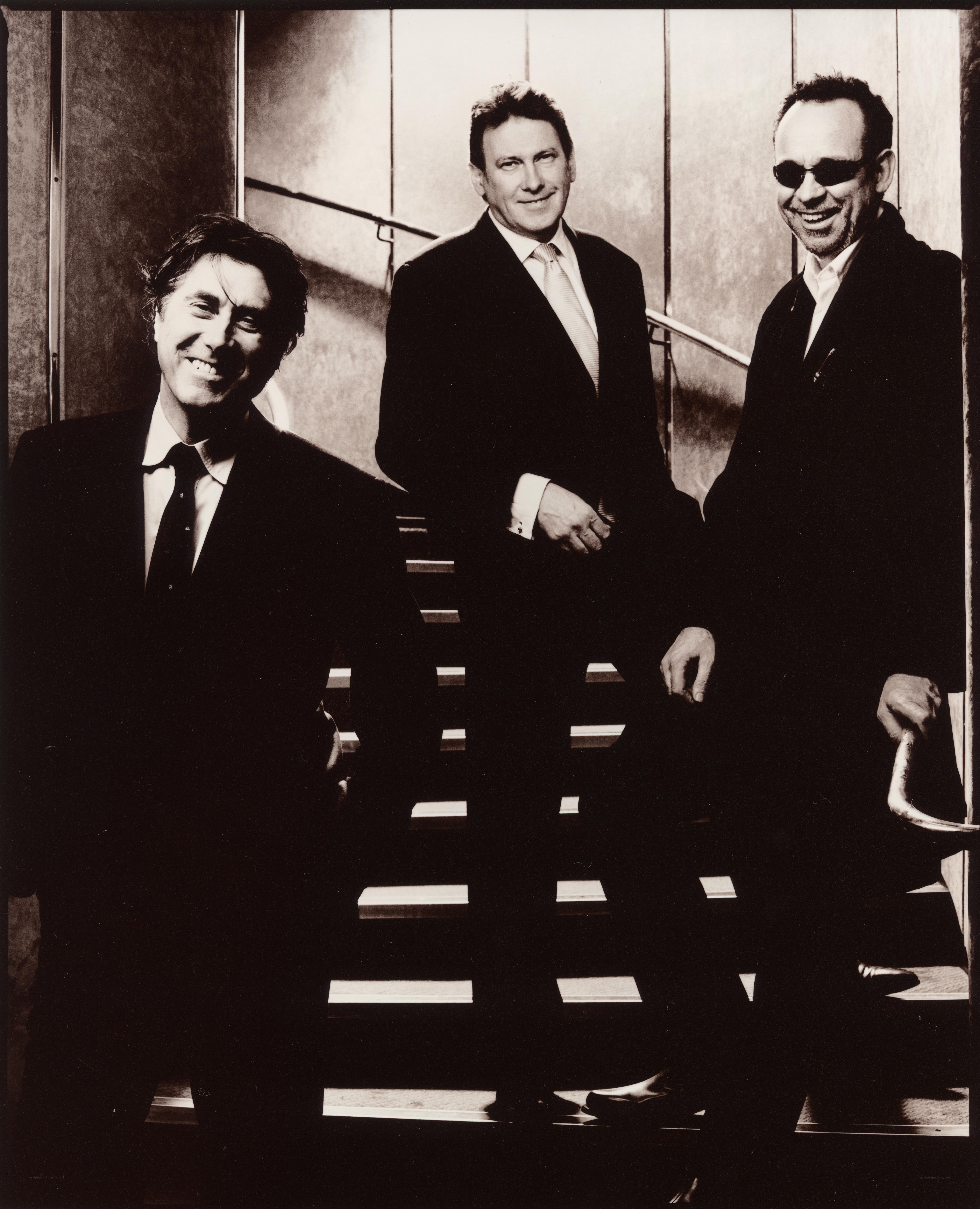 three men in suits on stairs