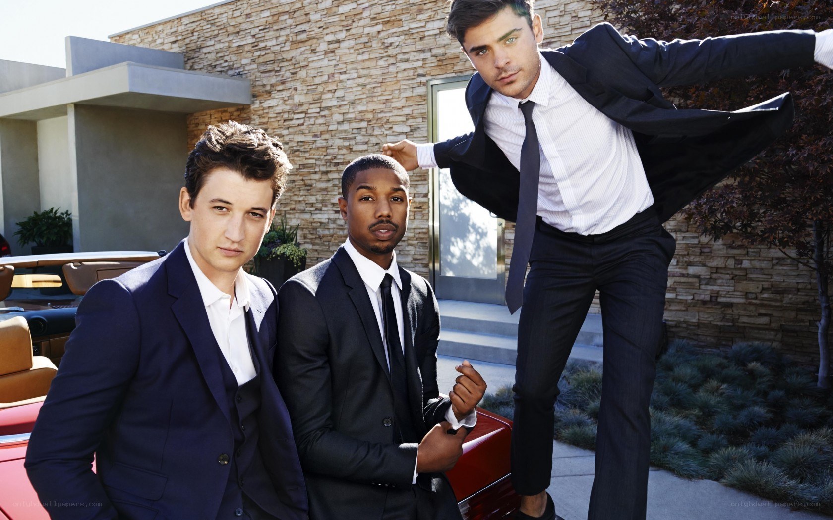 Three men in suits posing outdoors