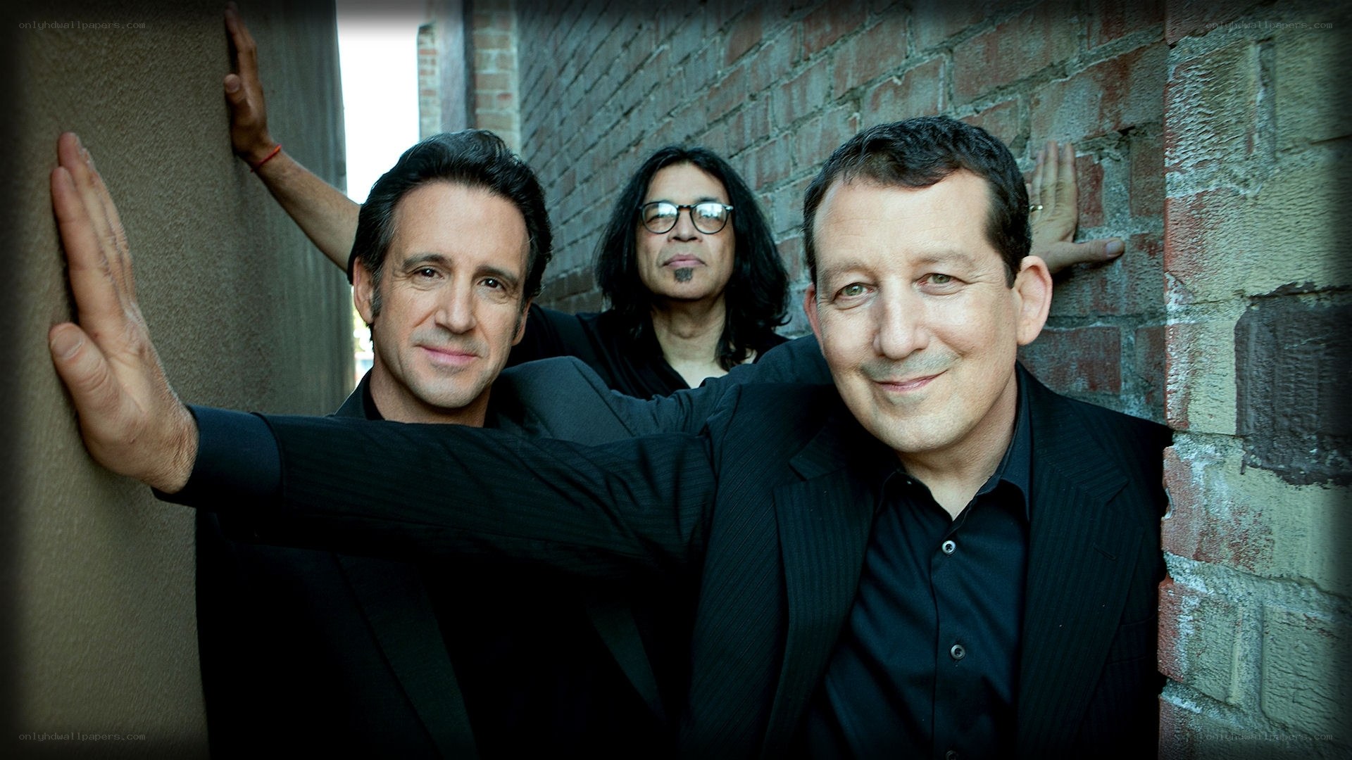 three men in suits posing