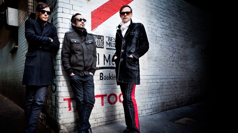 three men in sunglasses on a street