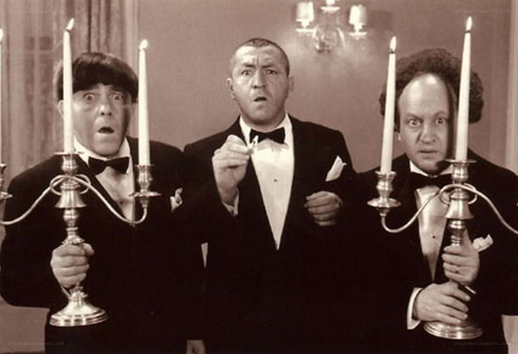 Three men in tuxedos with candlesticks